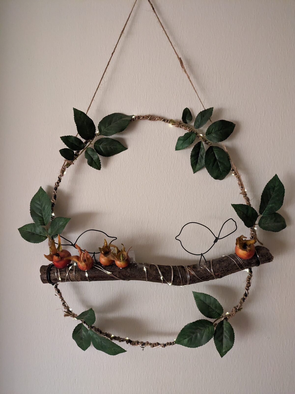 Rund krans med gröna blad och en liten figur