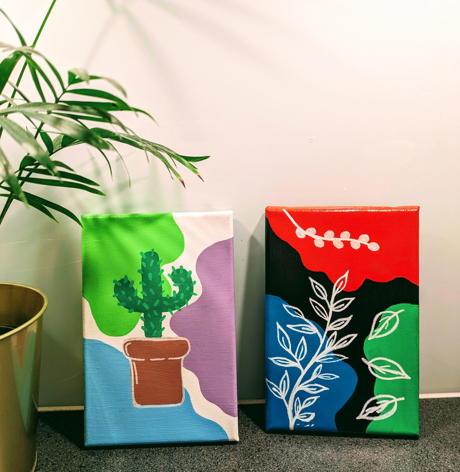 Två små planteringsaskar i rött och grönt