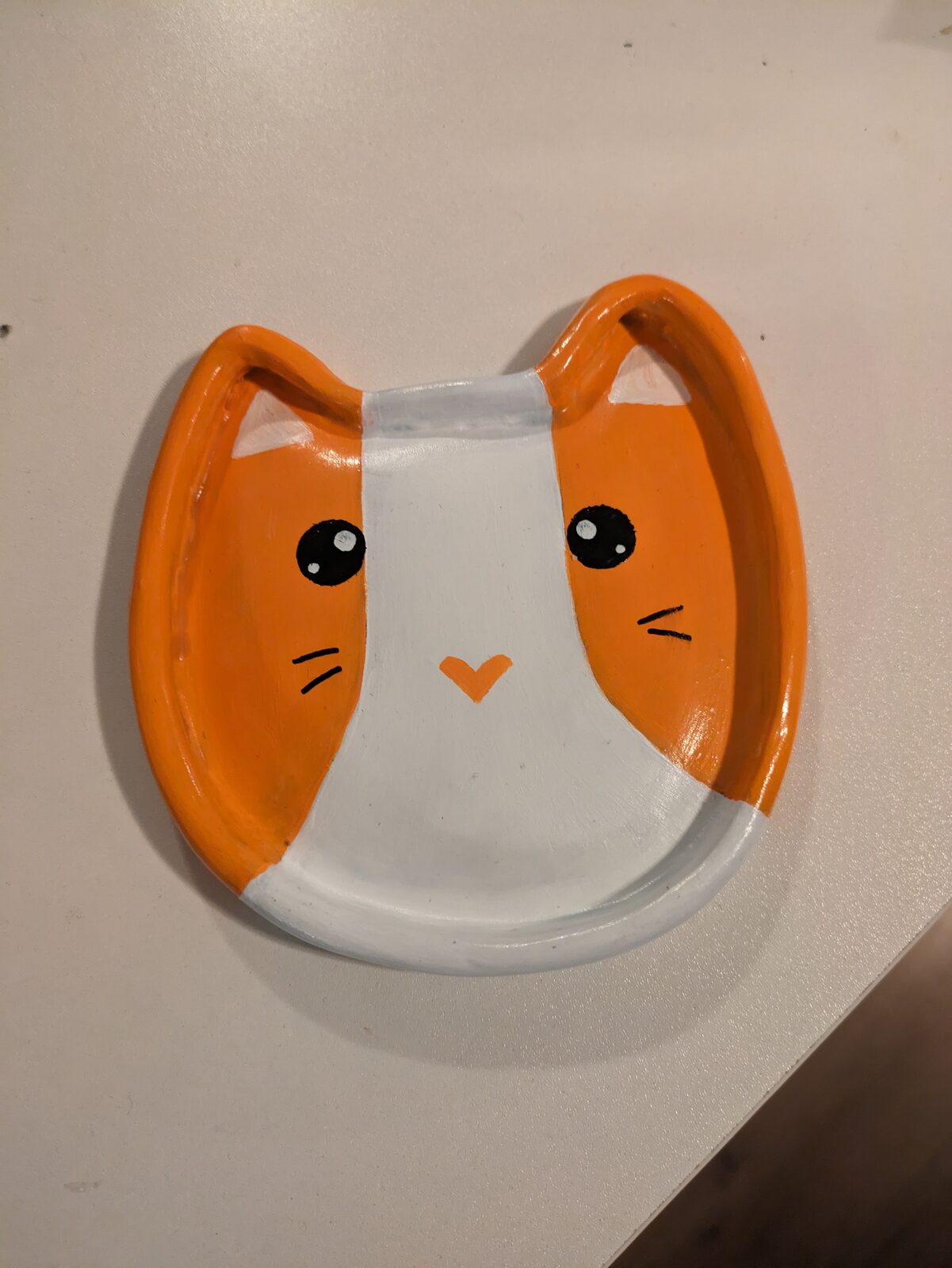 Vit keramikform med orange öron, kattansikte
