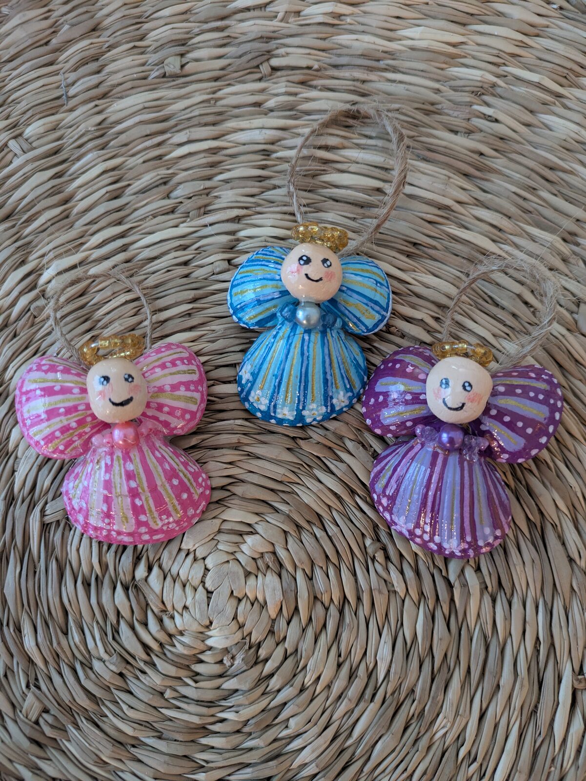 Tre änglafigurer i blått, orange och grönt